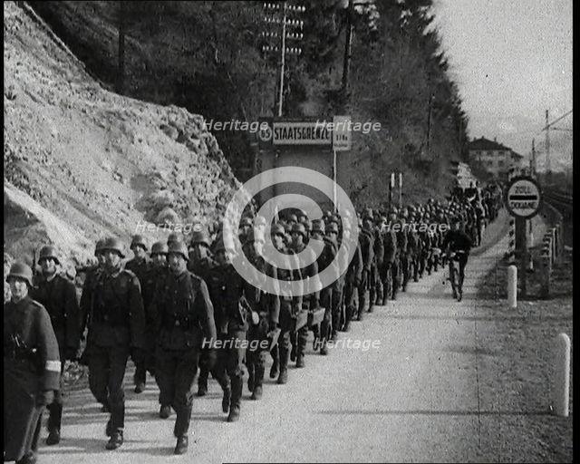 A Line of Male German Soldiers Marching Through a Customs Point Alongside a High Bank..., 1938. Creator: British Pathe Ltd.