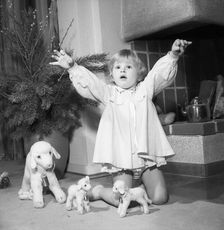 A litte girl playing with her christmas gifts, Sweden, 1955