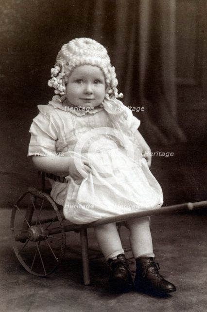 A little girl in a cart, c1910. Creator: Unknown.