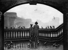 A man and a boy feeding the birds by Blackfriars Bridge, London, 1926-1927