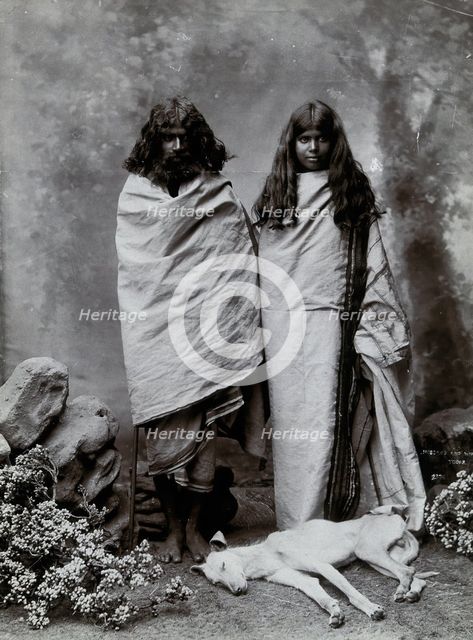 A man and woman of the Toda tribe standing in a photographic studio, with a dog lying..., c1900. Creator: Unknown.