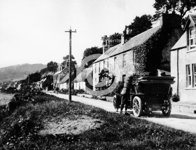 A man by his car in a village lane, 1900. Artist: Unknown