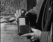 A Man Holding a Bottle of Liquor, 1932. Creator: British Pathe Ltd