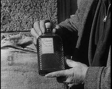 A Man Holding a Bottle of Liquor, 1932. Creator: British Pathe Ltd