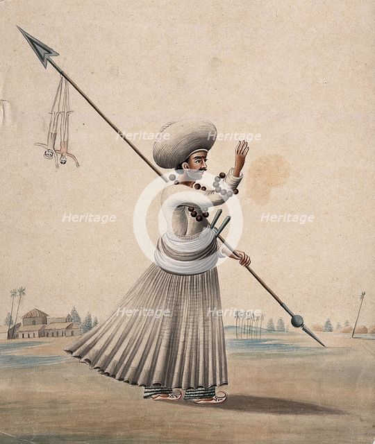 A man holding a long arrow with two puppets (?) hanging from it, (between 1800 and 1899?). Creator: Unknown.