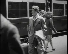 A Man in a Casual Suit and Carrying a Coat and Suitcase Walking Along a Platform Having..., 1938. Creator: British Pathe Ltd