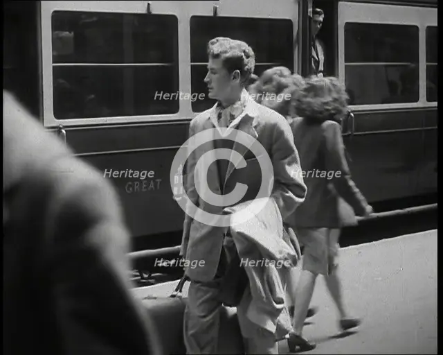 A Man in a Casual Suit and Carrying a Coat and Suitcase Walking Along a Platform Having..., 1938. Creator: British Pathe Ltd.