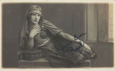 A man in drag, poses wearing delicate attire; curled up on a piece of furniture, [1910-1919?]. Creator: Unknown