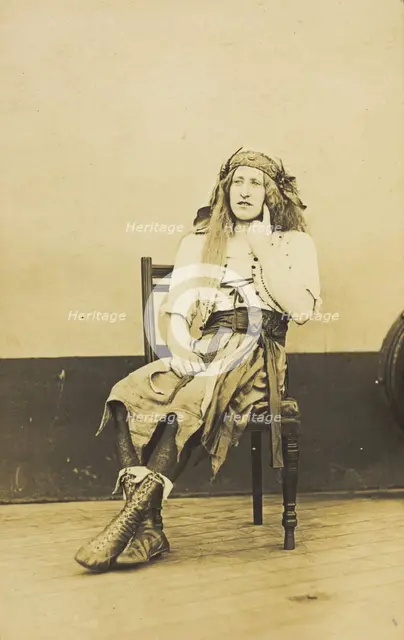 A man in drag sits pensively on a chair, on the deck of a ship, (between 1910 and 1919?). Creator: Unknown.