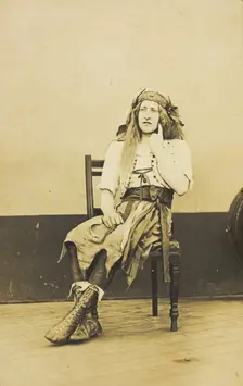 A man in drag sits pensively on a chair, on the deck of a ship, (between 1910 and 1919?). Creator: Unknown