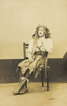 A man in drag sits pensively on a chair, on the deck of a ship, (between 1910 and 1919?). Creator: Unknown