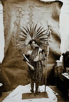 A man of an Amazonian tribe, holding a spear and wearing a feathered head-dress, in a..., 1900. Creator: Marc Ferrez