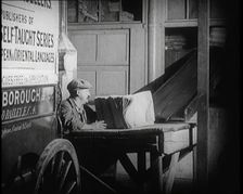 A Man Loading Bundles of Newspapers Into a Van, 1921. Creator: British Pathe Ltd