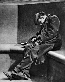 A man sleeping on Blackfriars Bridge, London, 1926-1927.Artist: Walter Benington