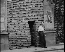 A Man Standing Outside the Frontage of a Building Obscured By Sandbags Next To an..., 1937. Creator: British Pathe Ltd