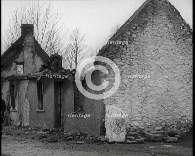A Man Standing Outside a Burnt Out Cottage in Ireland, Holding a Bicycle, 1921. Creator: British Pathe Ltd.