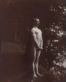 A man posing naked, standing with his chest out, arms down and hands clasped, approx 1900. Creator: Unknown