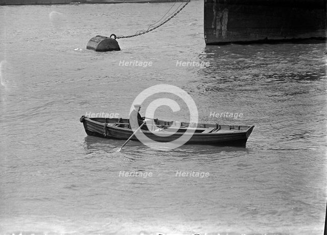 A man rowing a boat in London docks, c1945-c1965. Artist: SW Rawlings