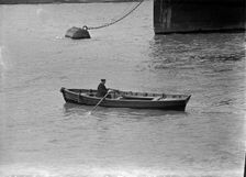 A man rowing a boat in London docks, c1945-c1965. Artist: SW Rawlings