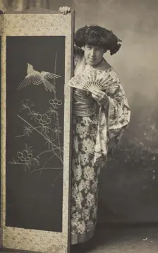 A man wearing a kimono posing from behind a screen, 1906. Creator: Unknown