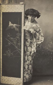 A man wearing a kimono posing from behind a screen, 1906. Creator: Unknown