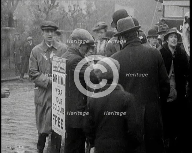A Man Wearing a Sandwich Board Advertising 'Pathe Gazette' Reading 'Cup Final Wear Your..., 1921. Creator: British Pathe Ltd.