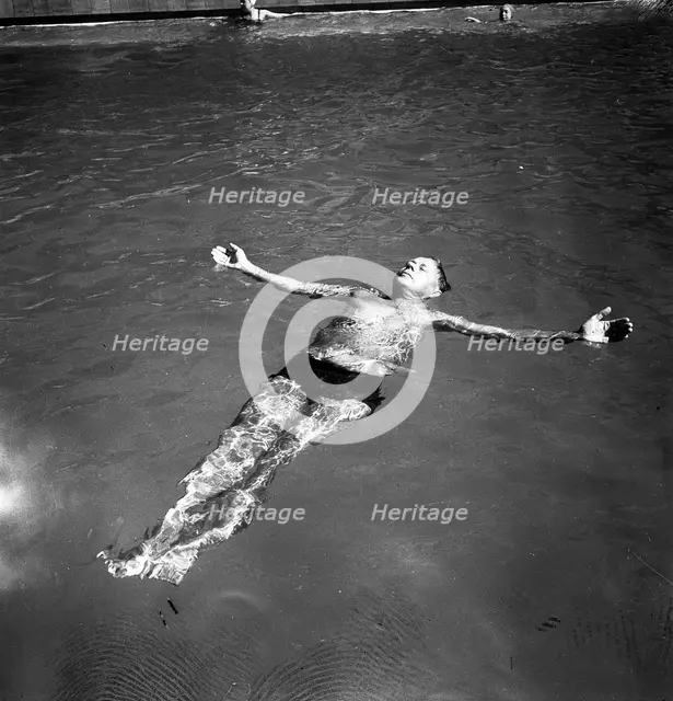 A man takes a refreshing dip in a swimming pool during the hot summer, Sweden, 1943. Creator: Karl Sandels.