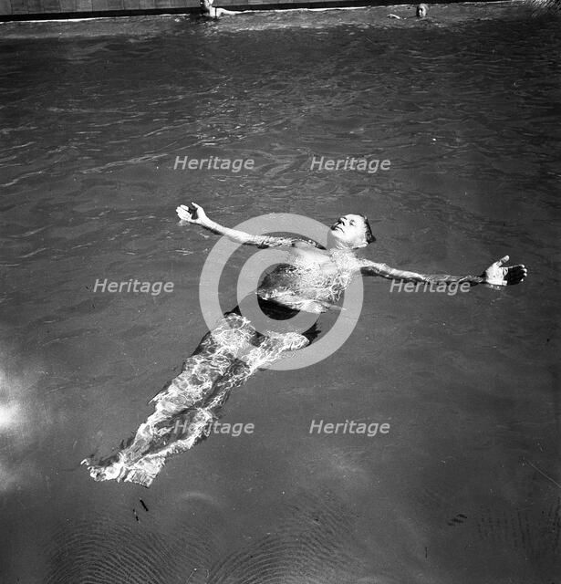 A man takes a refreshing dip in a swimming pool during the hot summer, Sweden, 1943. Artist: Karl Sandels