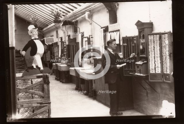 A man uses the clocking in machine, Rowntree factory, Yorkshire, 1929. Artist: Unknown