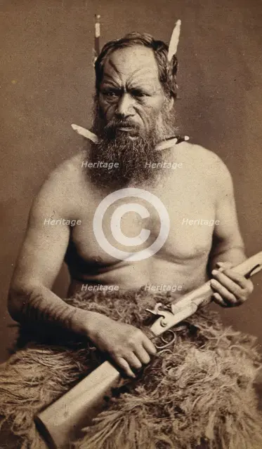 A Maori man with a tattoed face, holding a rifle, c1870s. Creator: James Bragge.