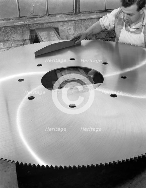 A machinist quality checking a six foot circular saw blade, Sheffield, South Yorkshire, 1963. Creator: Michael Walters.