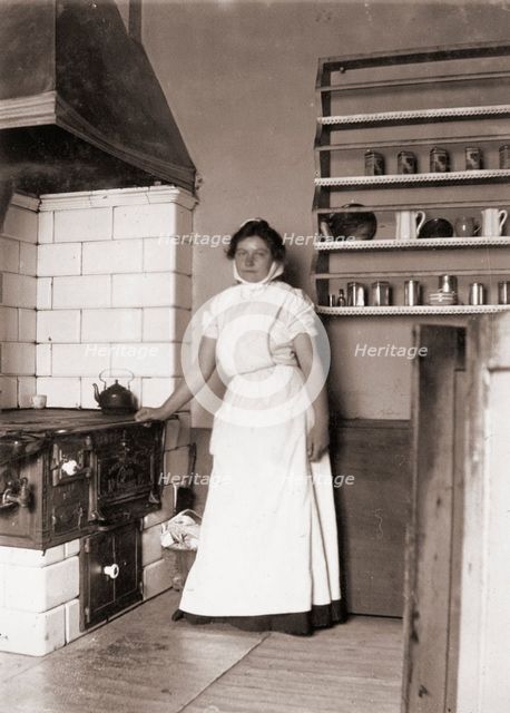 A maid, named Ruth, by the stove, 1905. Creator: Unknown.