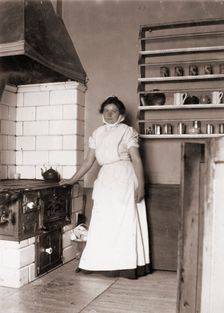 A maid, named Ruth, by the stove, 1905. Creator: Unknown