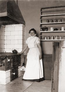 A maid, named Ruth, by the stove, 1905
