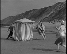 A Male Actor With a Moustache and Bowler Hat Being Chased Around a Changing Tent On a Beach...,1920s Creator: British Pathe Ltd