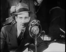A Male American Civilian in a Press Room Speaking at a Microphone That Has the Words NBC..., 1930s. Creator: British Pathe Ltd