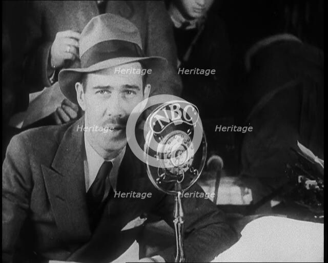A Male American Civilian in a Press Room Speaking at a Microphone That Has the Words NBC..., 1930s. Creator: British Pathe Ltd.