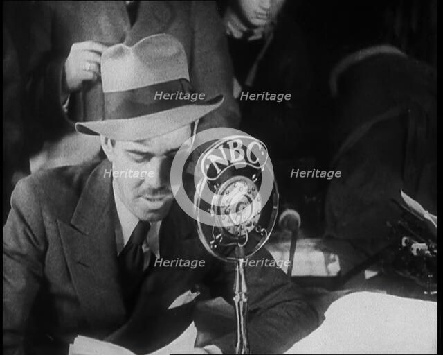 A Male American Civilian in a Press Room Speaking at a Microphone That Has the Words NBC..., 1930s. Creator: British Pathe Ltd.