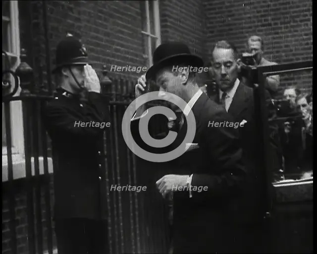 A Male British Police Officer Saluting King George VI, the British Monarch who is Exiting..., 1939. Creator: British Pathe Ltd.