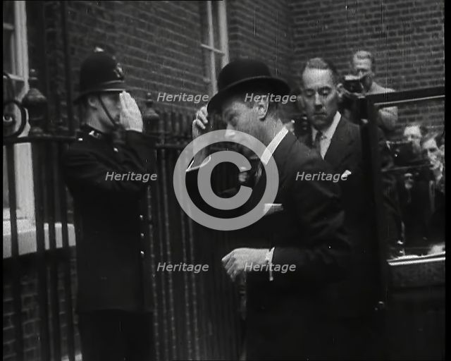 A Male British Police Officer Saluting King George VI, the British Monarch who is Exiting..., 1939. Creator: British Pathe Ltd.