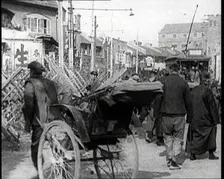 A Male Chinese Civilian Pulling Rickshaws Through the Streets of Shanghai Past Barricades, 1920s. Creator: British Pathe Ltd
