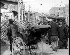 A Male Chinese Civilian Pulling Rickshaws Through the Streets of Shanghai Past Barricades, 1920s. Creator: British Pathe Ltd