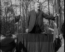 A Male Civilian Makes a Speech from a Stand in Front of a Crowd of Male Civilians Carrying..., 1924. Creator: British Pathe Ltd