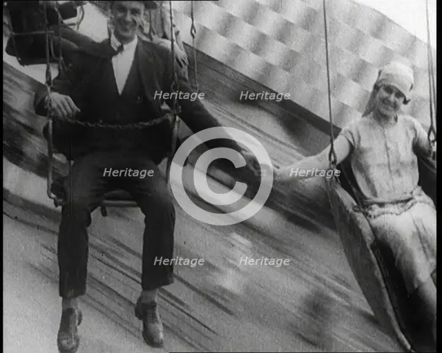 A Male Civilian and a Female Civilian Holding Hands as They Are Spun Through the Air on a..., 1924. Creator: British Pathe Ltd.
