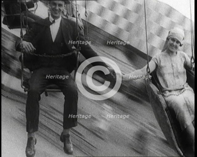 A Male Civilian and a Female Civilian Holding Hands as They Are Spun Through the Air on a..., 1924. Creator: British Pathe Ltd.