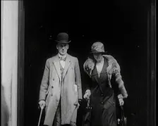 A Male Civilian and Female Civilian Emerging from a Building, 1924. Creator: British Pathe Ltd