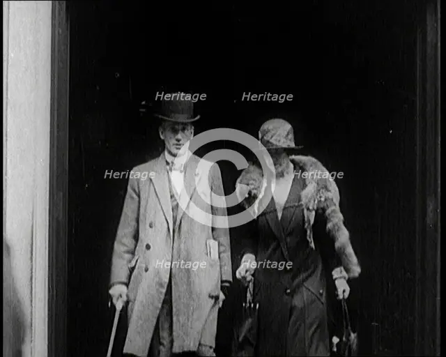 A Male Civilian and Female Civilian Emerging from a Building, 1924. Creator: British Pathe Ltd.