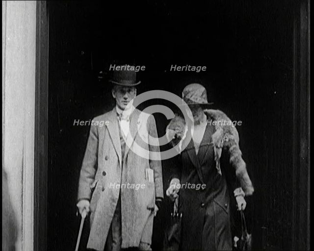 A Male Civilian and Female Civilian Emerging from a Building, 1924. Creator: British Pathe Ltd.
