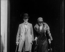 A Male Civilian and Female Civilian Emerging from a Building, 1924. Creator: British Pathe Ltd