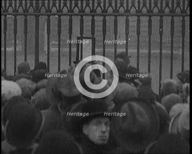 A Male Civilian Holding up a Bulletin from the Doctor to Crowds Gathering Outside..., 1929. Creator: British Pathe Ltd.